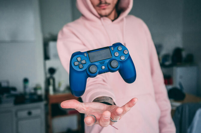 Man in a hoodie throwing a controller in the air